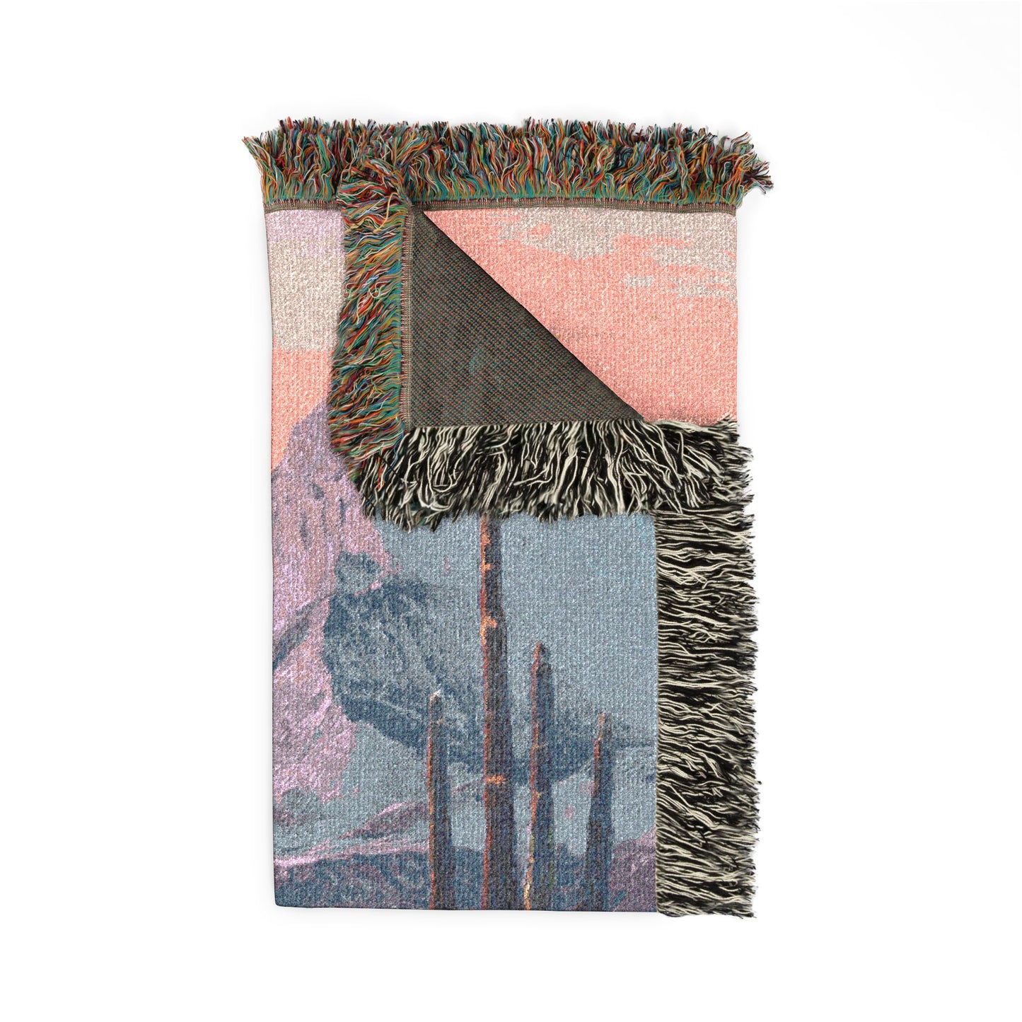 Woven blanket with fringe edges featuring a landscape design on a white background