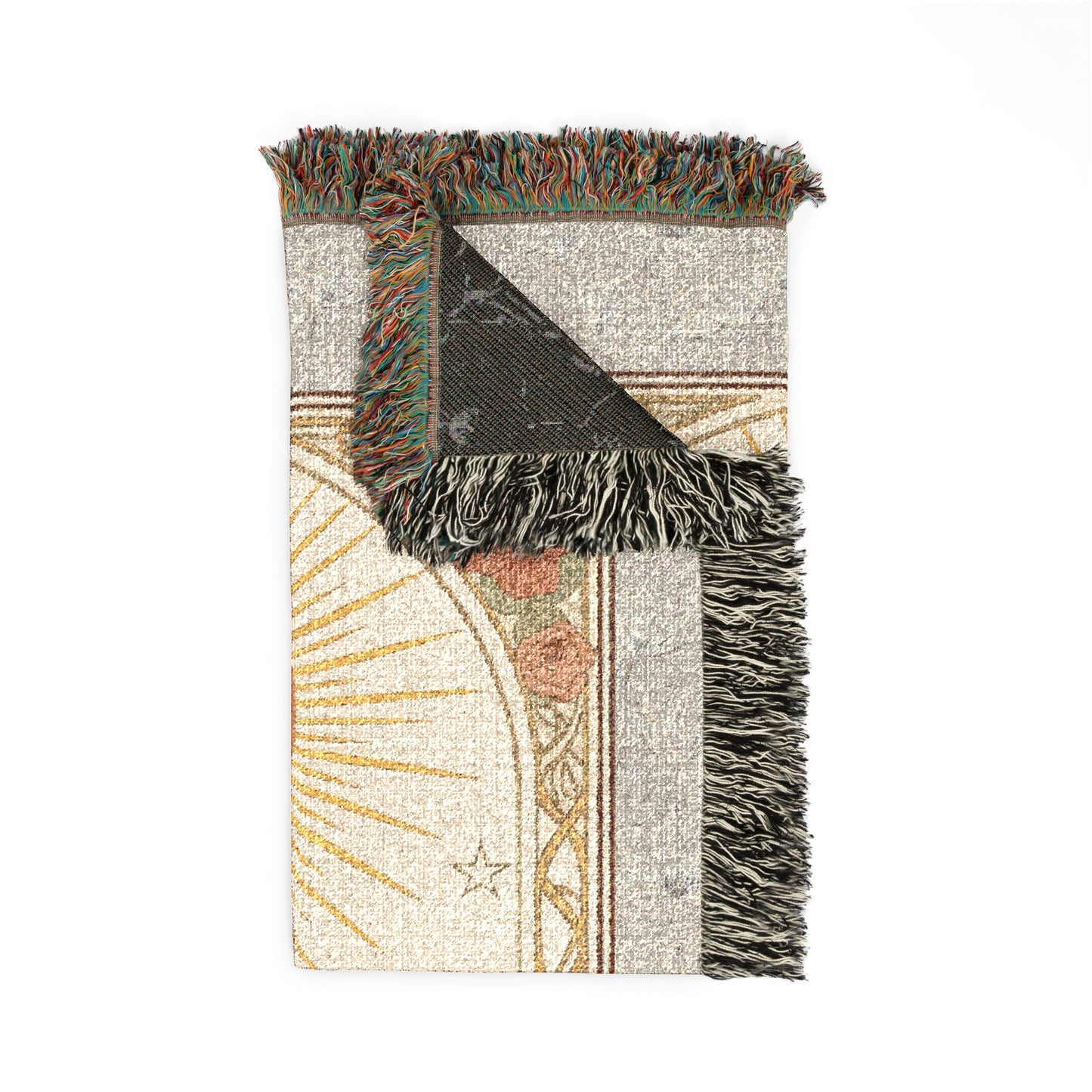 A rectangular woven throw blanket with fringed edges, shown flat on a white background. The blanket features a cream and beige base with a partial sunburst design in gold, a small star, muted floral accents in dusty pink and terracotta, and a dark charcoal corner folded over to reveal the reverse side.