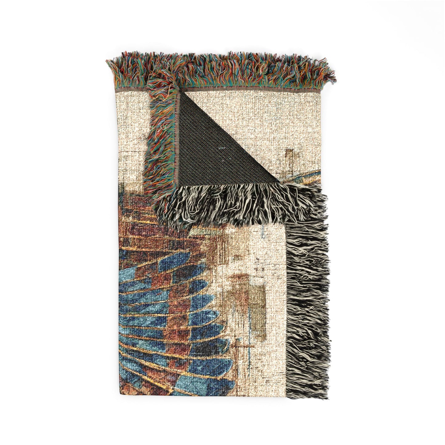 A rectangular woven throw blanket with fringed edges, featuring an abstract geometric pattern in beige, blue, brown, and black on a white background.