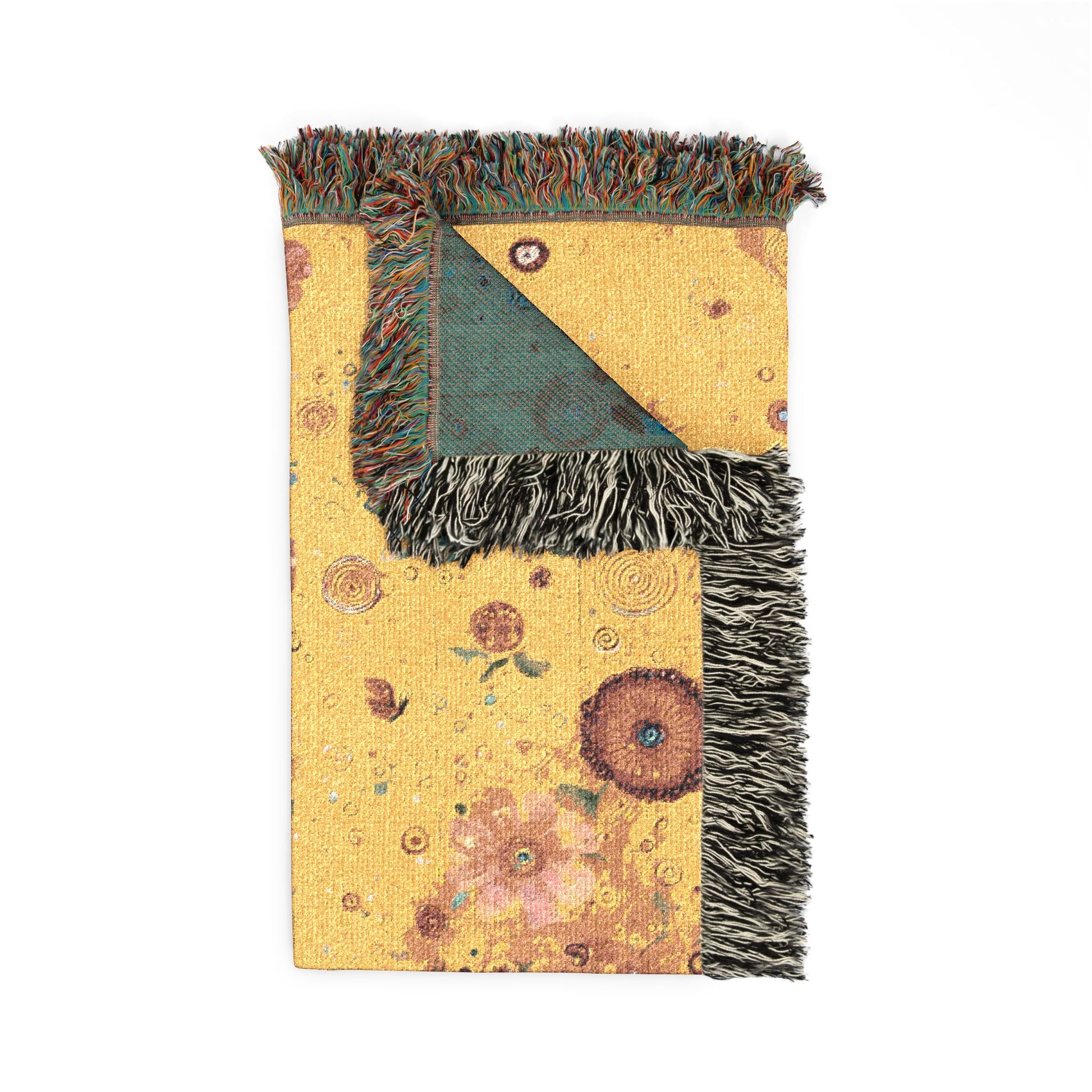 Decorative throw blanket with floral patterns and fringed edges on a white background