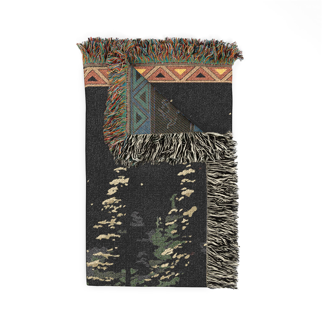 Woven blanket with geometric patterns and fringes on a white background