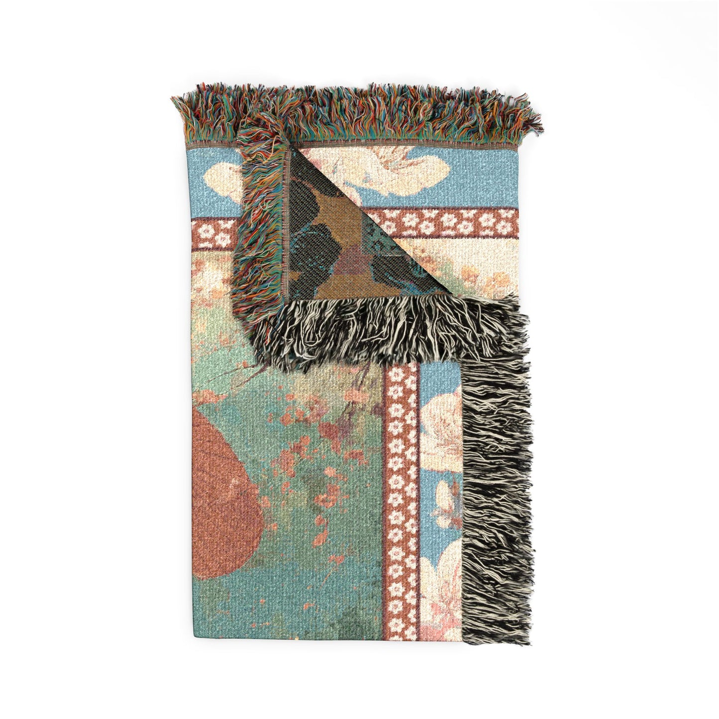 Decorative blanket with floral patterns and fringed edges on a white background