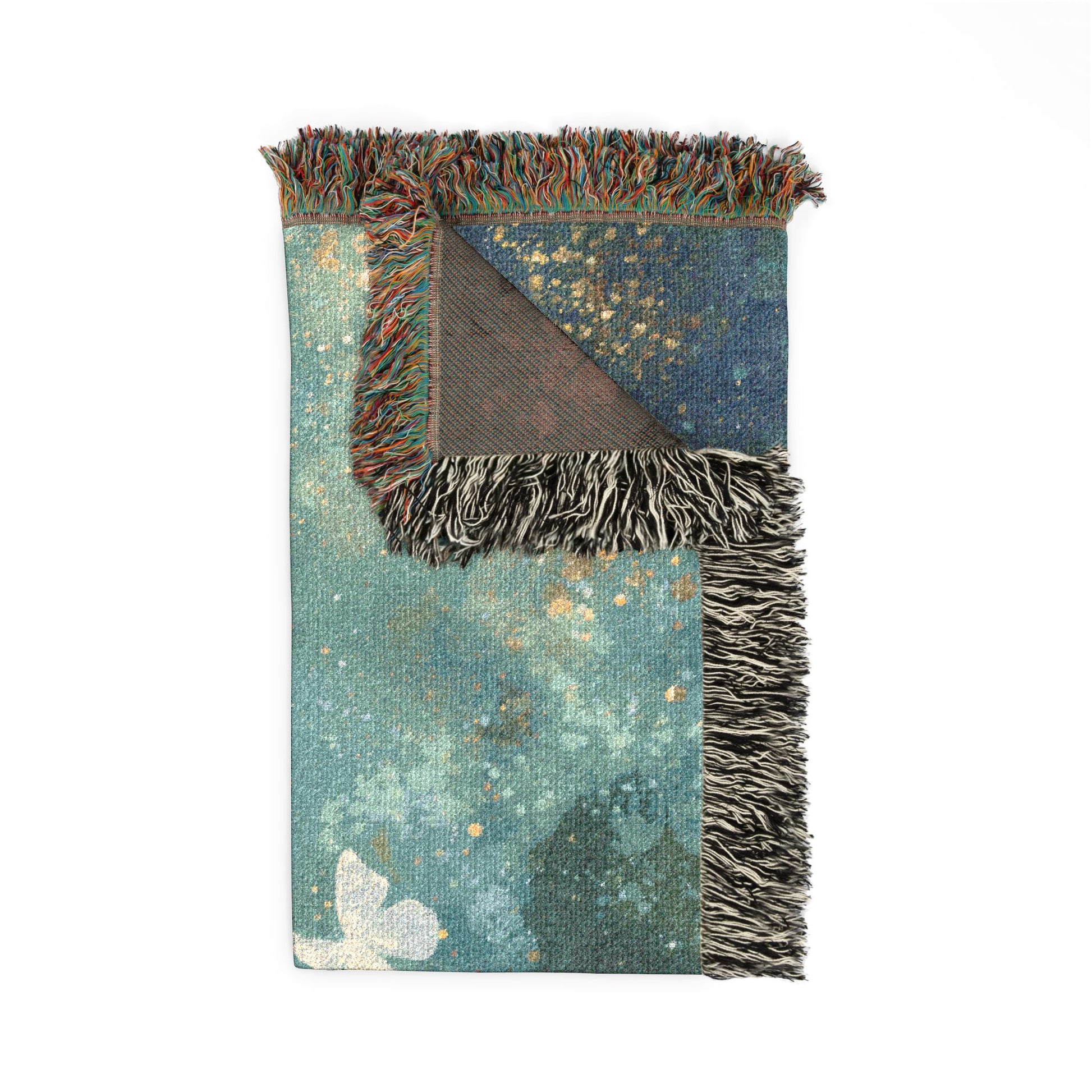 A folded blanket with a distressed teal and blue pattern, featuring multicolor fringe on two sides and a brown backing visible where the corner is folded.