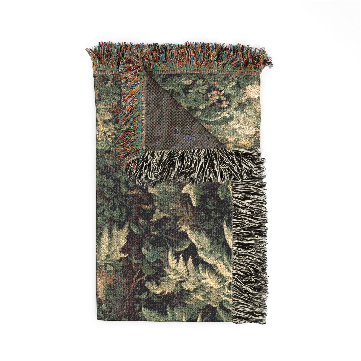 A rectangular woven throw blanket with fringe on two short ends, featuring a detailed botanical and fern pattern in shades of green, beige, and brown. The top portion is shown from the front, while the bottom corner reveals a dark reverse side.