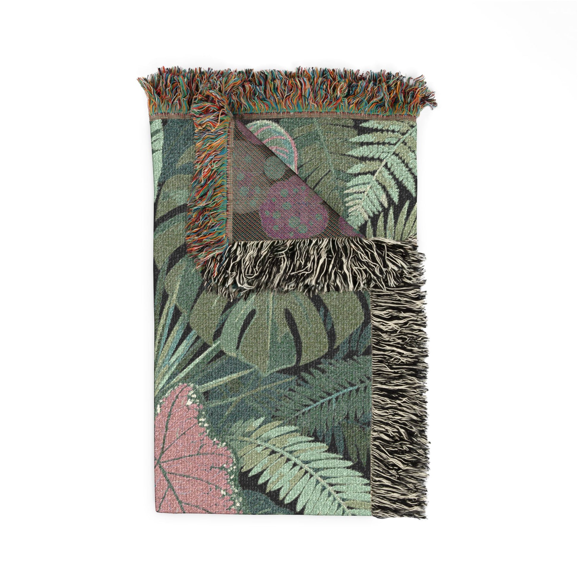 Tropical leaf patterned blanket with fringed edges on a white background