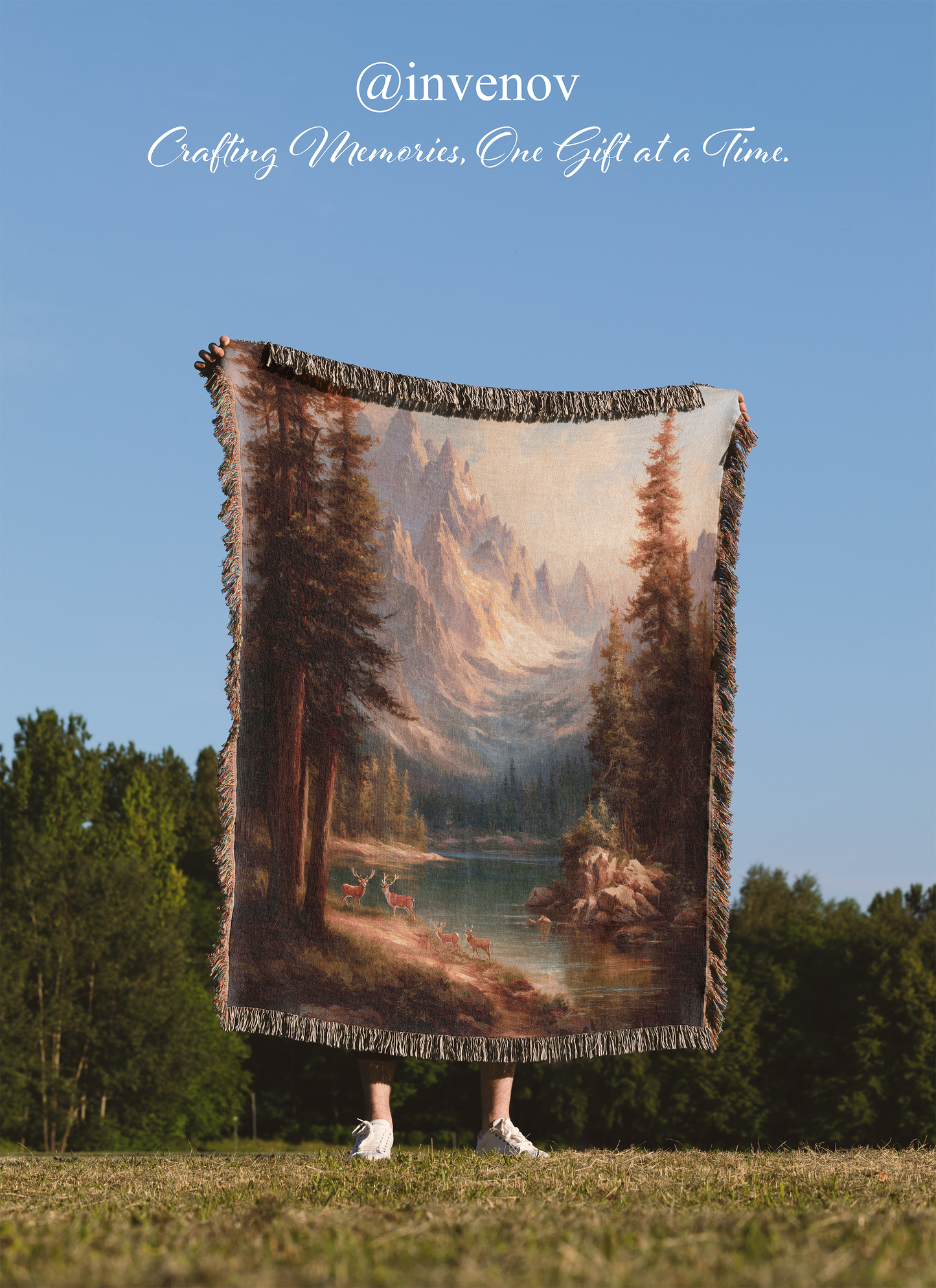 Person holding a scenic blanket with a mountain landscape in a natural setting