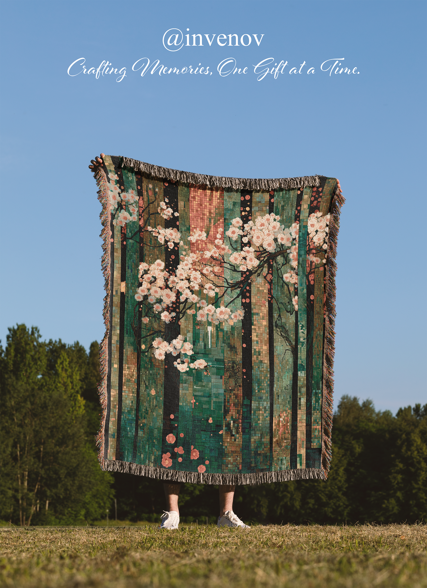 Person holding a decorative blanket with floral patterns against a blue sky and trees.