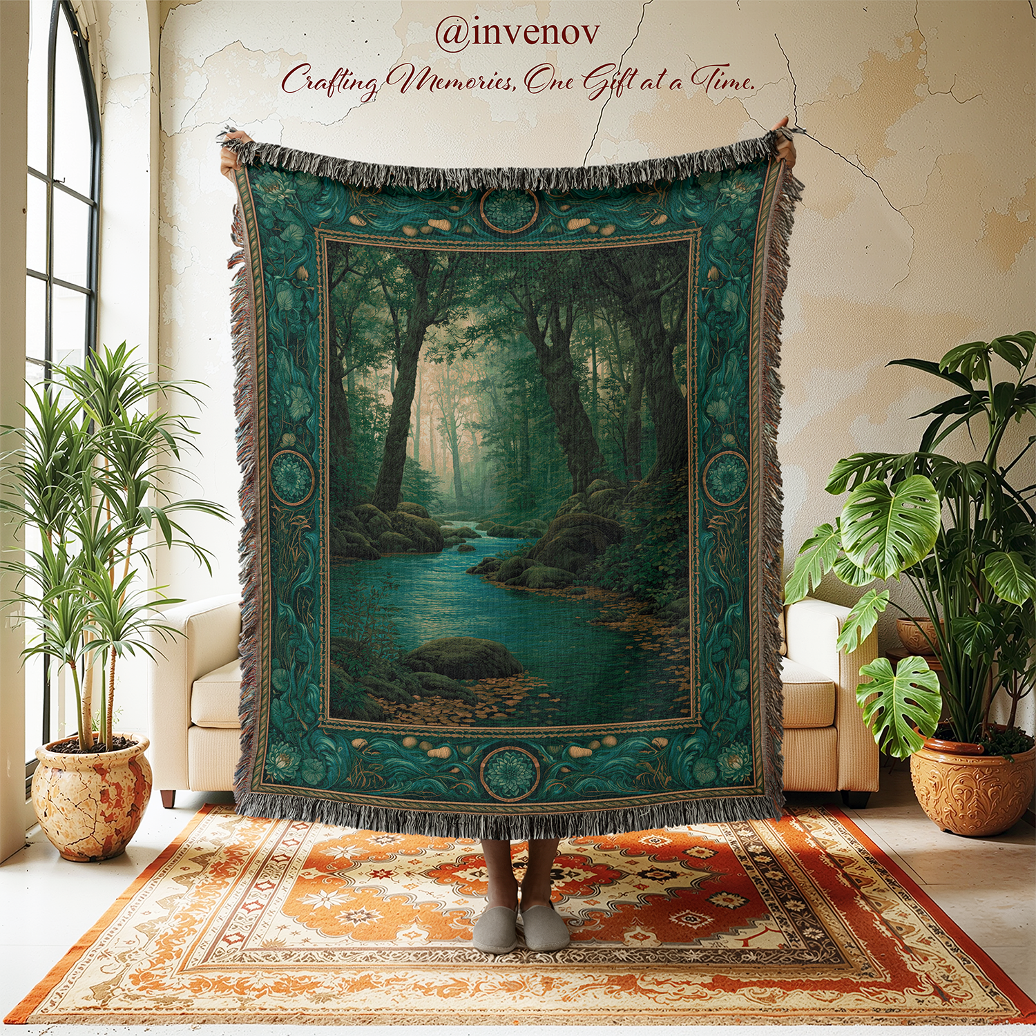 A large woven tapestry featuring a forest river scene in teal, green, and brown tones, held up in a styled room with plants, chairs, and a rug. The tapestry has fringe around the edges and decorative border motifs.