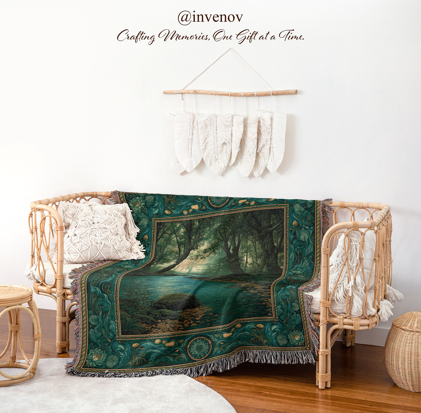 A bohemian-style green forest-themed throw blanket with fringe is draped over a rattan daybed in a styled room setting. The blanket features a detailed print of a mystical forest stream surrounded by trees, with a teal and gold color palette.