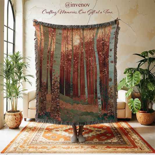 A large woven throw blanket featuring a forest scene with birch trees, held up by a person whose feet are visible at the bottom in a cozy living room setting with plants and a rug.