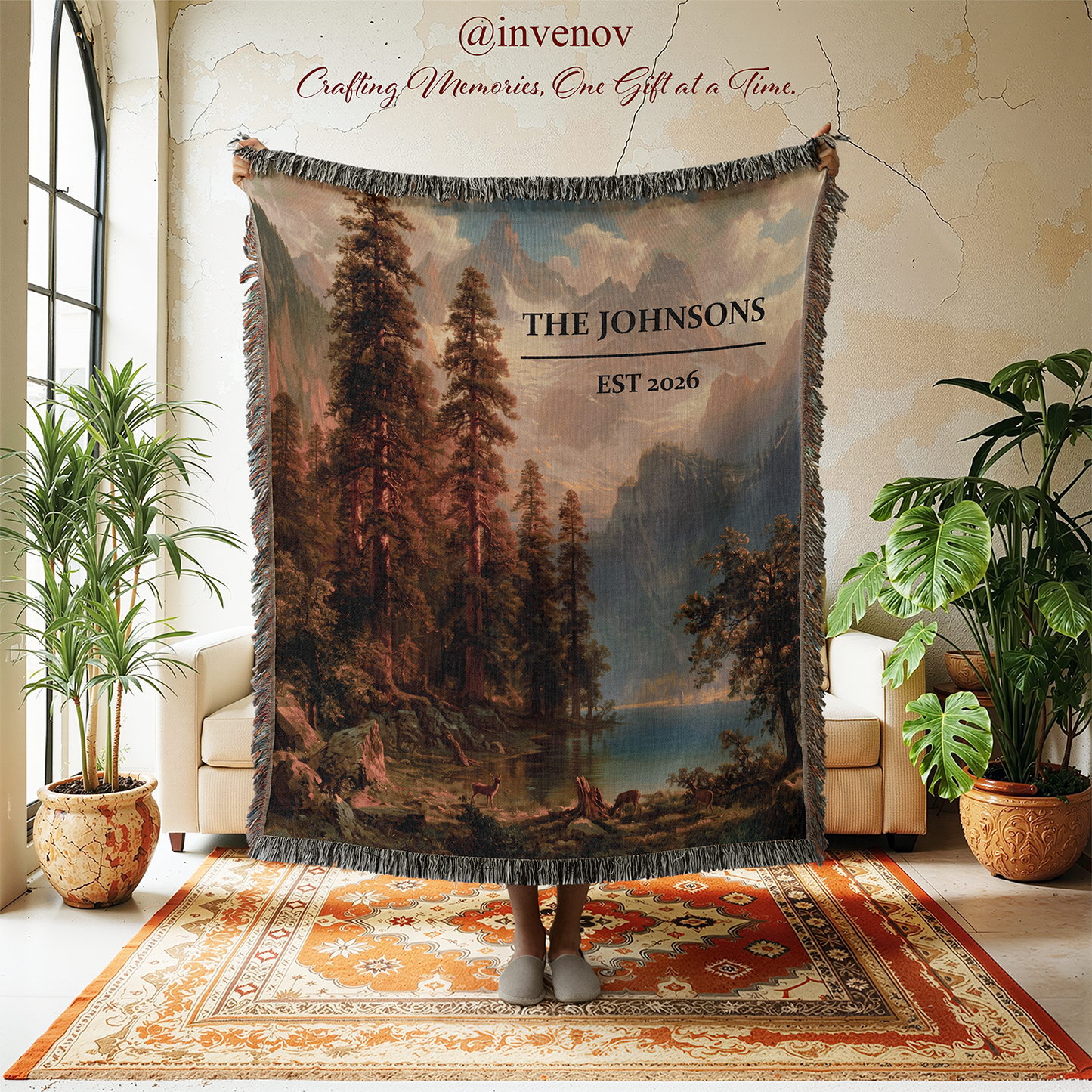 A personalized landscape tapestry with fringe is held up by a person in a living room setting. The tapestry features a scenic print of a forest lake 