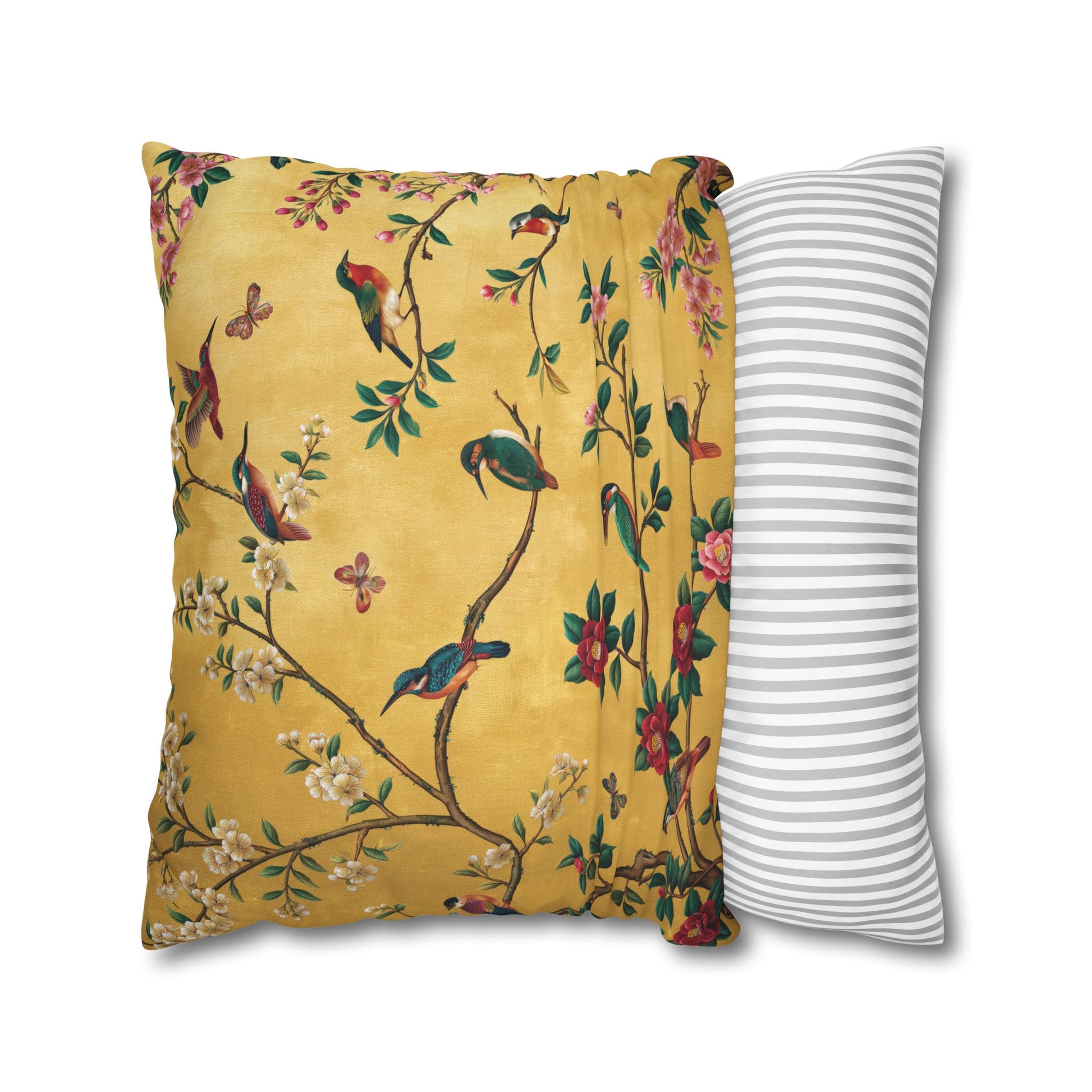 Decorative pillow with floral and bird pattern next to a striped pillow on a white background