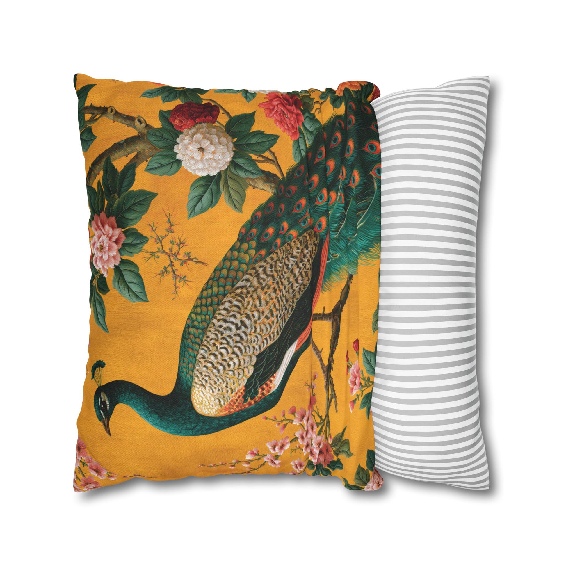 Decorative pillow with peacock design on a yellow background next to a striped pillow.