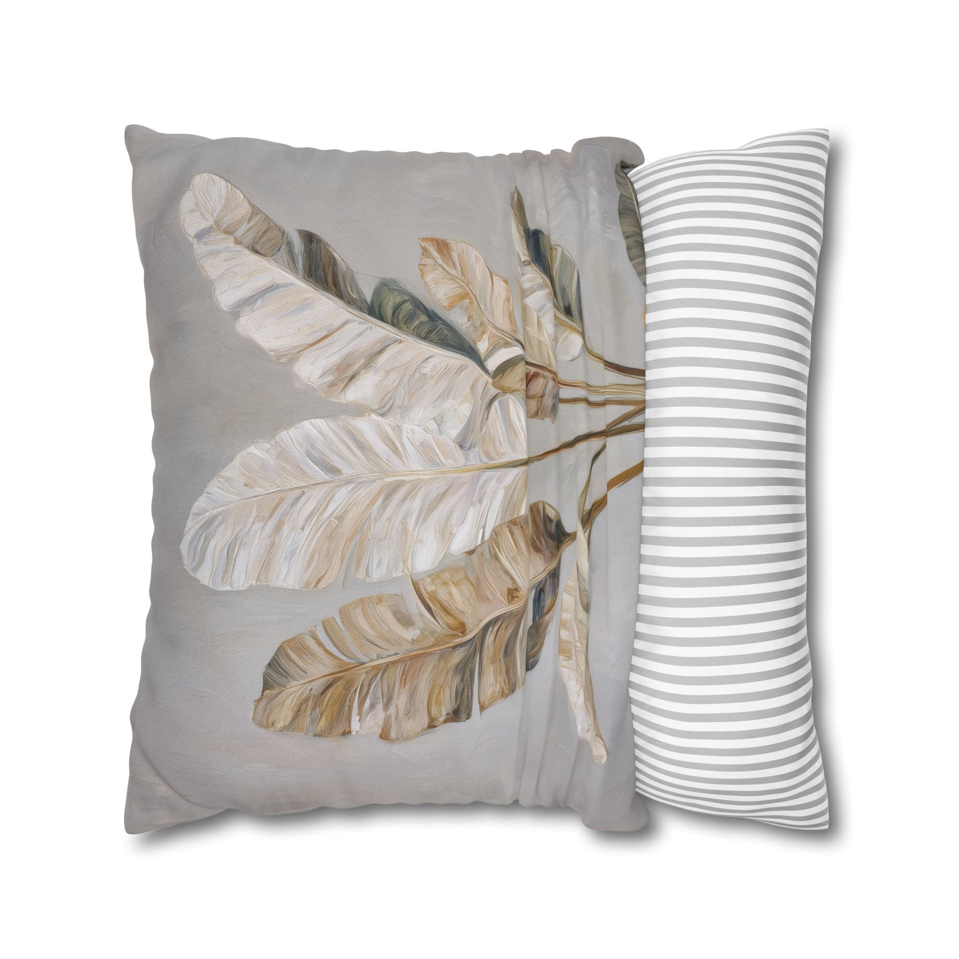 Decorative pillow with leaf pattern and striped pillow on a white background