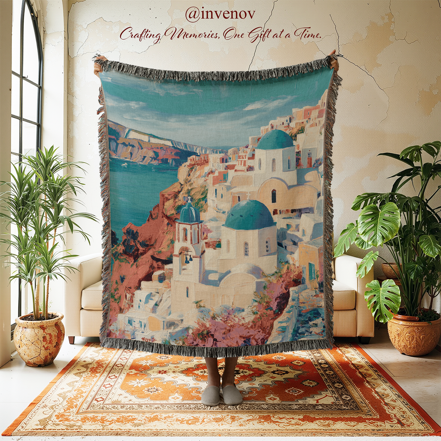 Person holding a colorful tapestry of a coastal town with blue domes in a room with plants and a rug.
