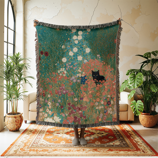 Decorative blanket with floral and cat design hanging in a room with plants and furniture.