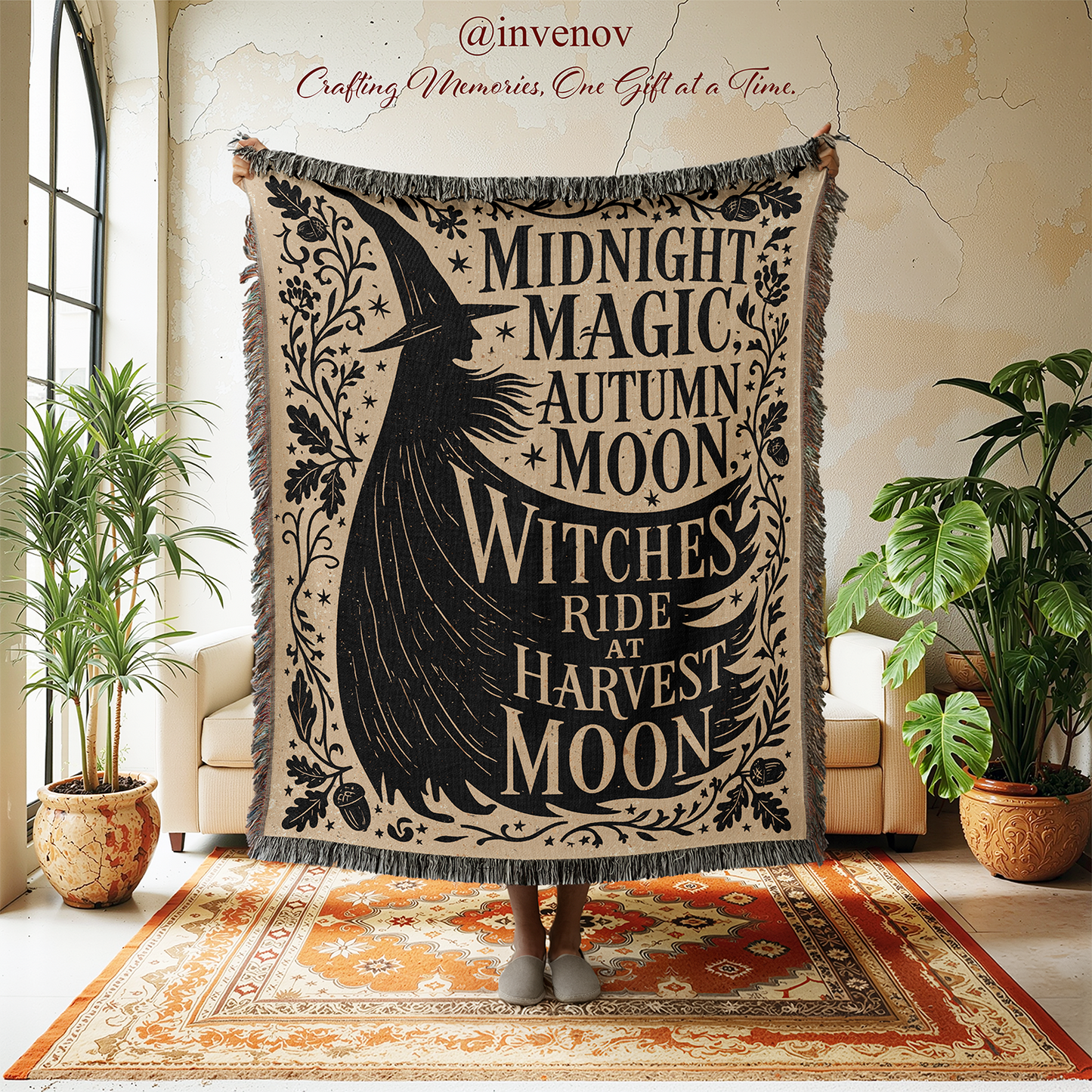 A person holds up a large woven tapestry with fringe edges in a cozy room. The tapestry features a black witch silhouette and the text 'MIDNIGHT MAGIC AUTUMN MOON WITCHES RIDE AT HARVEST MOON' on a warm beige background.