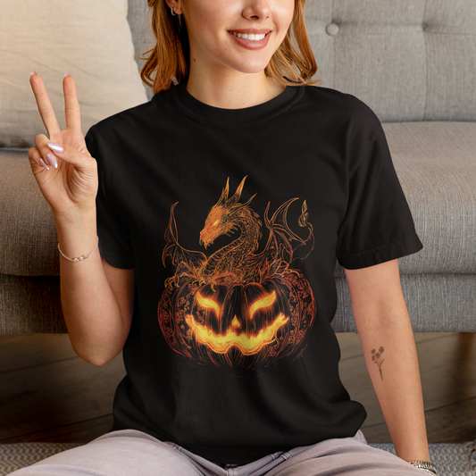 Person wearing a black t-shirt with a dragon and pumpkin design, sitting on the floor.