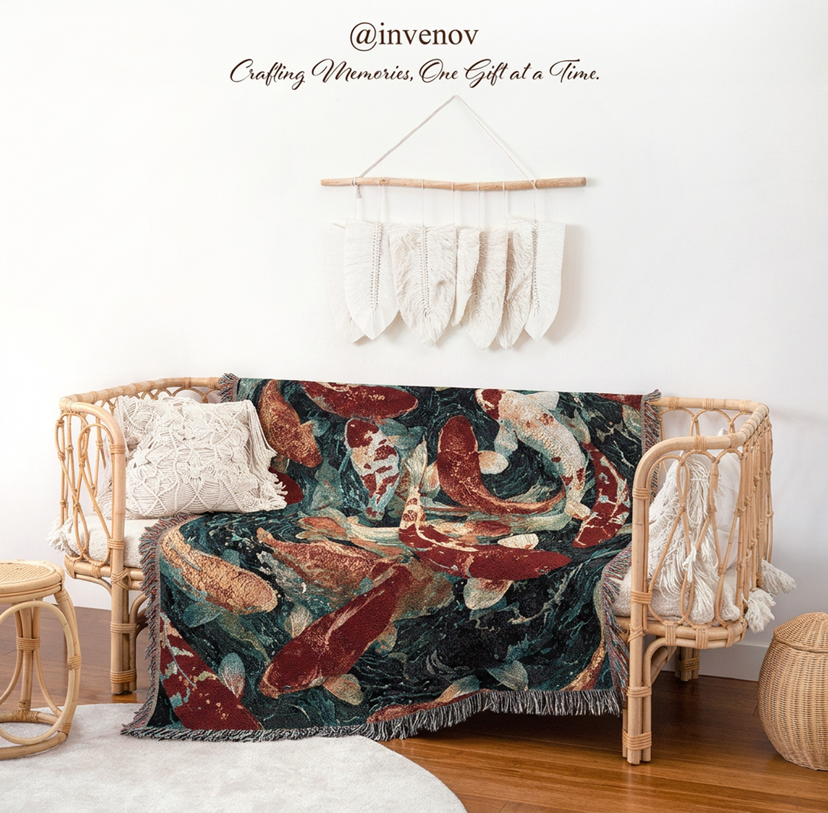 A woven throw blanket featuring a koi fish pattern in red, cream, and dark teal, draped over a rattan daybed in a styled room setting with a white wall and decorative hanging.