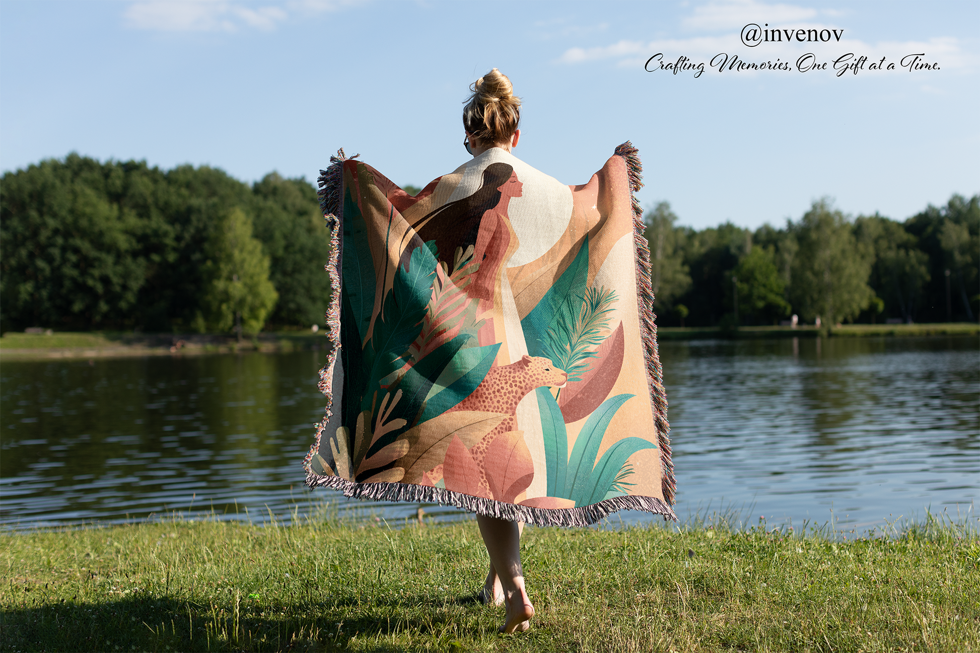 Person walking by a lake with a colorful towel draped over their shoulders, featuring nature-themed designs.
