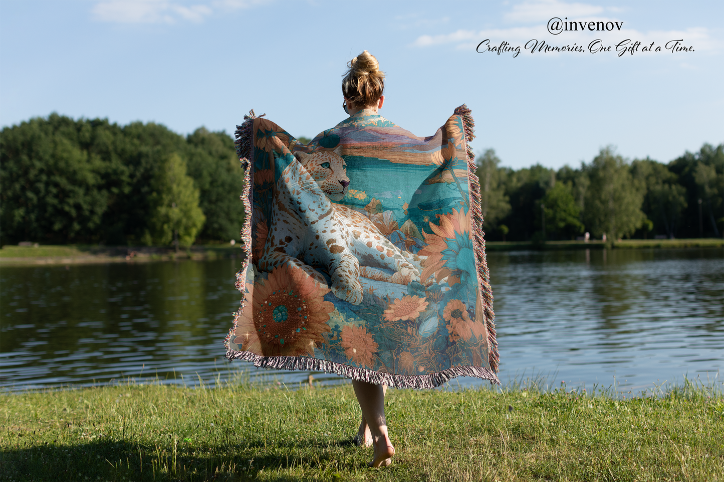 Person holding a leopard blanket by a lake with trees in the background