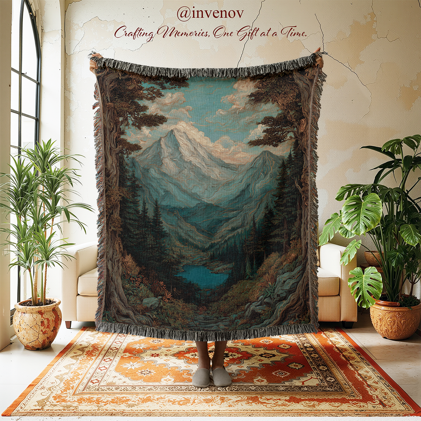 A large woven tapestry blanket featuring a mountain landscape with a lake, hanging in a styled room. A person's feet are visible at the bottom of the tapestry.