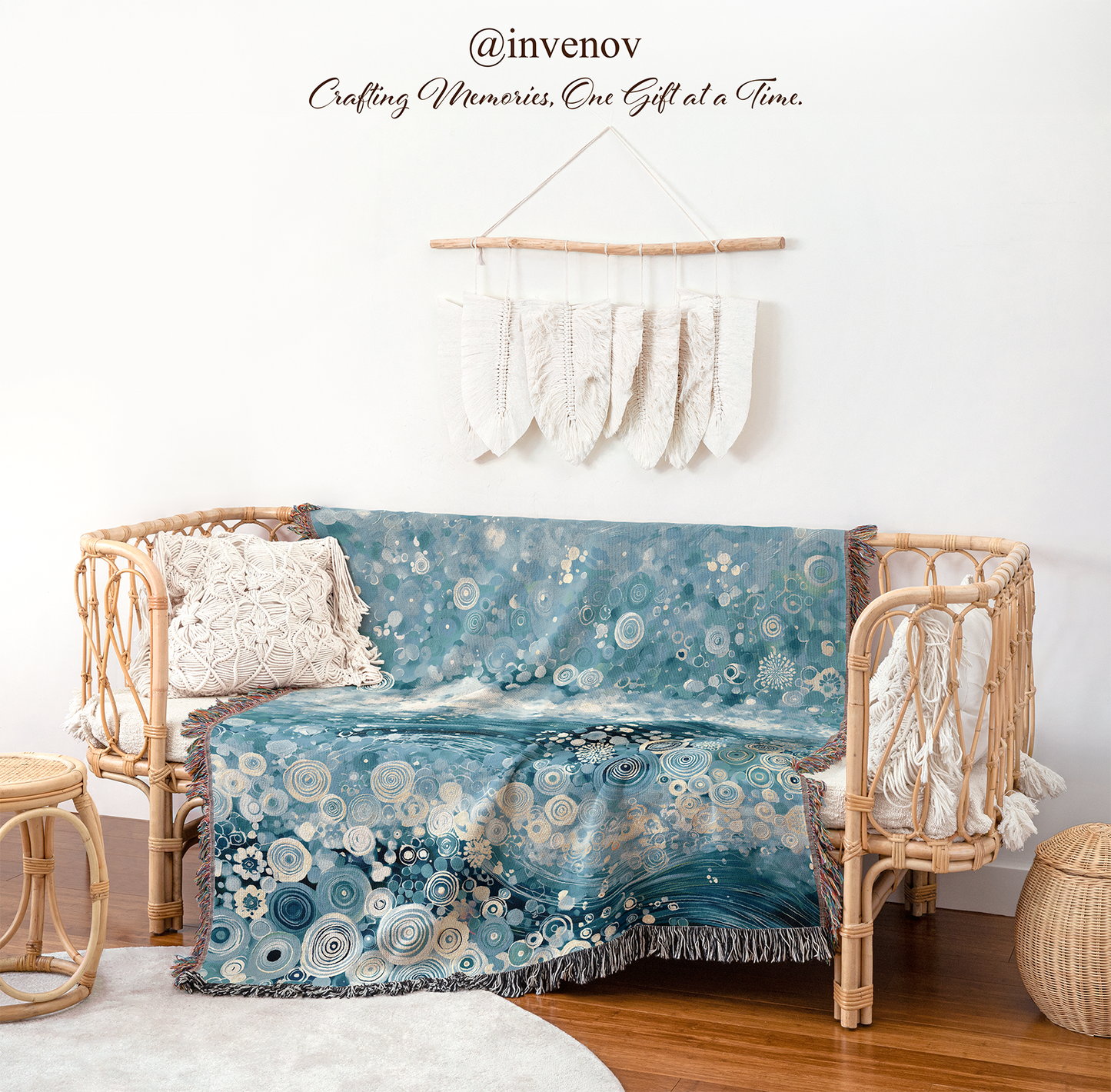 A blue and white bohemian-style throw blanket with a floral and circular pattern draped over a rattan daybed in a styled room setting.