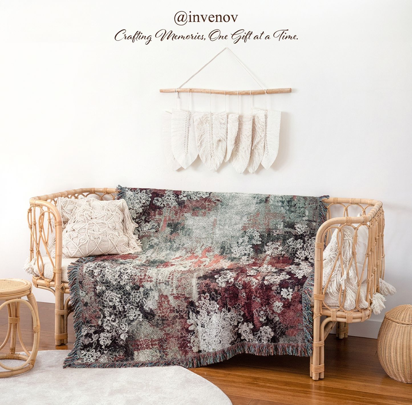 A woven rattan daybed styled in a bohemian room setting, draped with a multicolor floral and abstract patterned throw blanket. The daybed is decorated with a textured cream pillow and a matching cream fringed throw hanging from the right armrest.