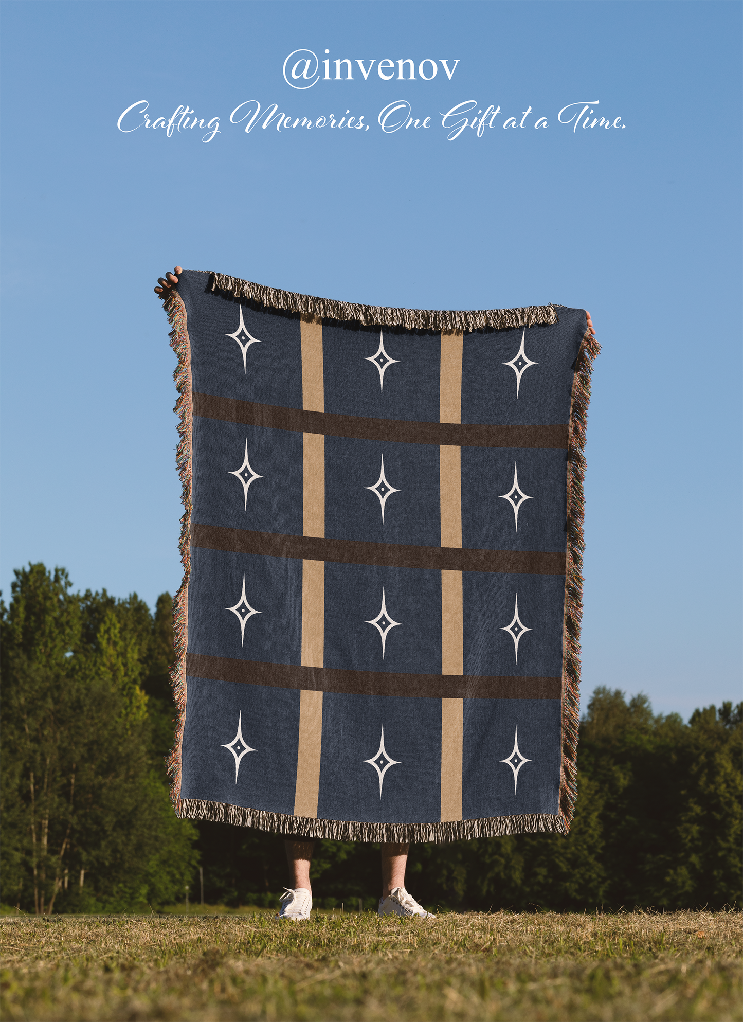 Person holding a decorative blanket with star patterns against a blue sky and trees.