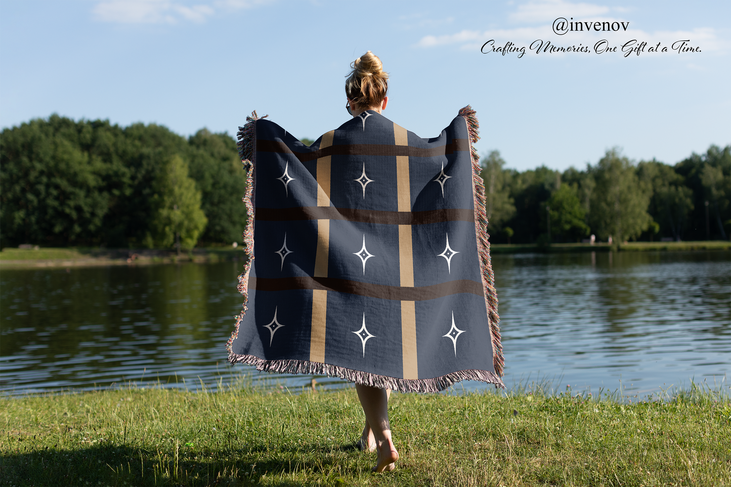 Person holding a star-patterned blanket by a lake 