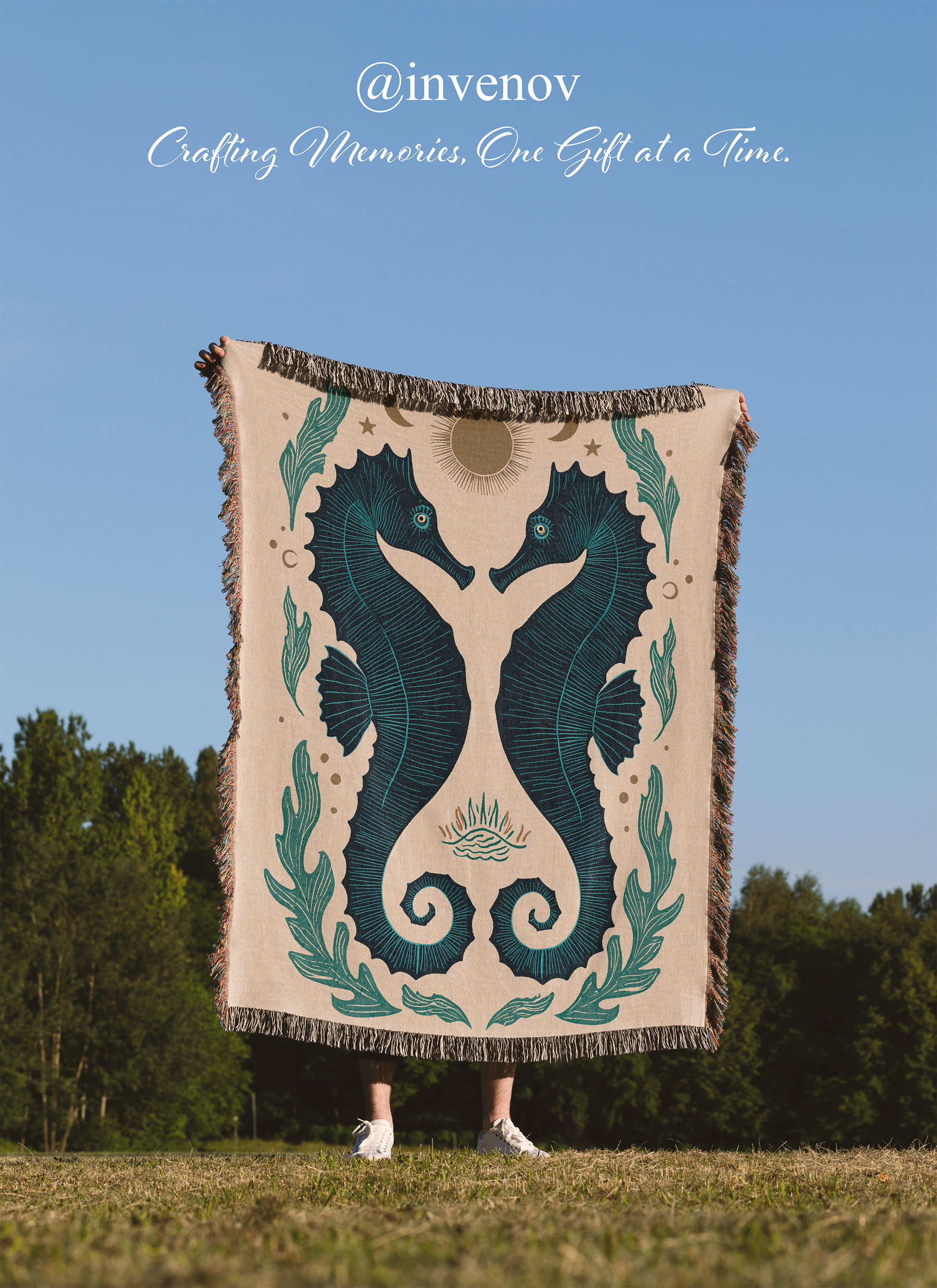 Person holding a decorative blanket with a seahorse design against a blue sky and trees.