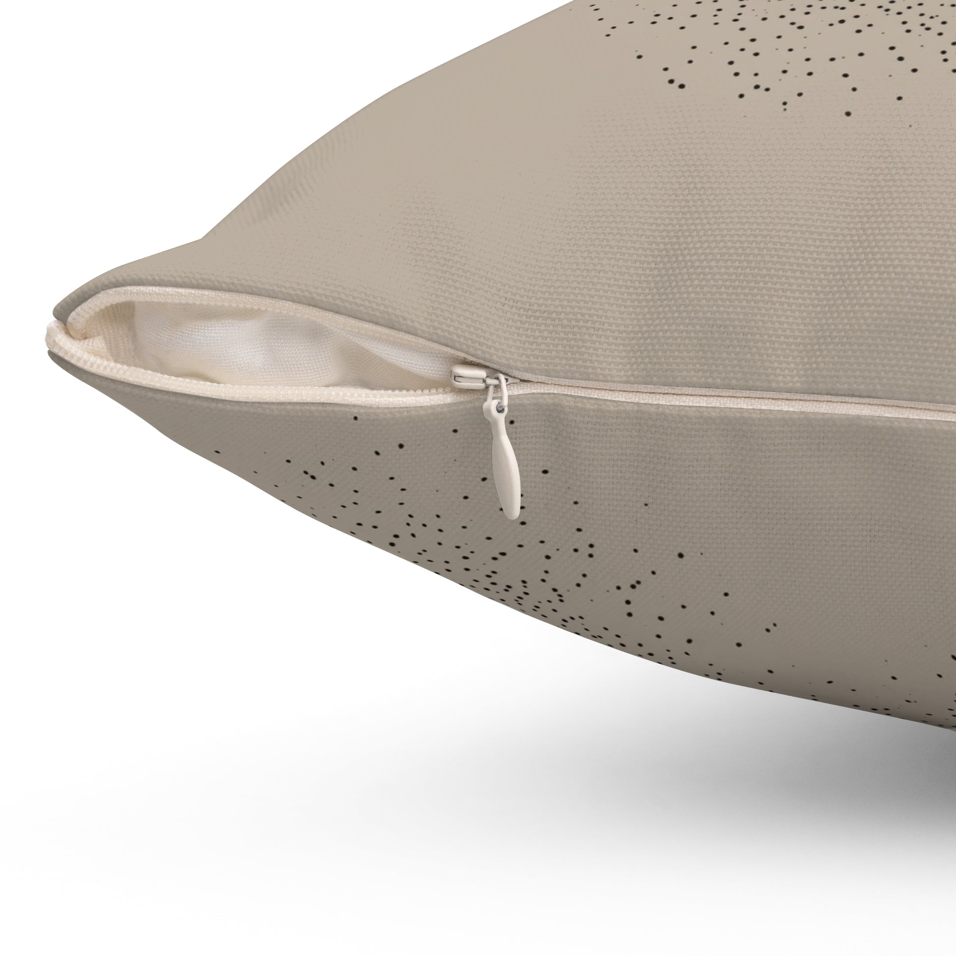 Close-up of a beige textured pillow cover with a zipper and small black dot pattern, shown on a white background.