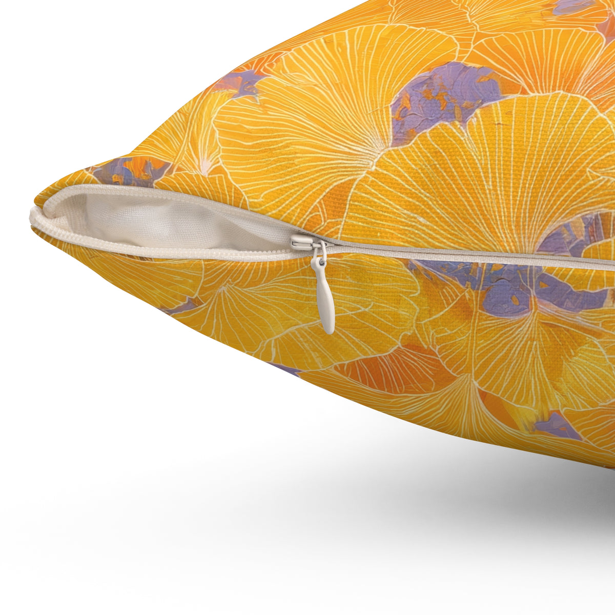 A close-up of a decorative throw pillow with a vibrant yellow and orange floral pattern accented by purple details, showing a white zipper opening against a white background.