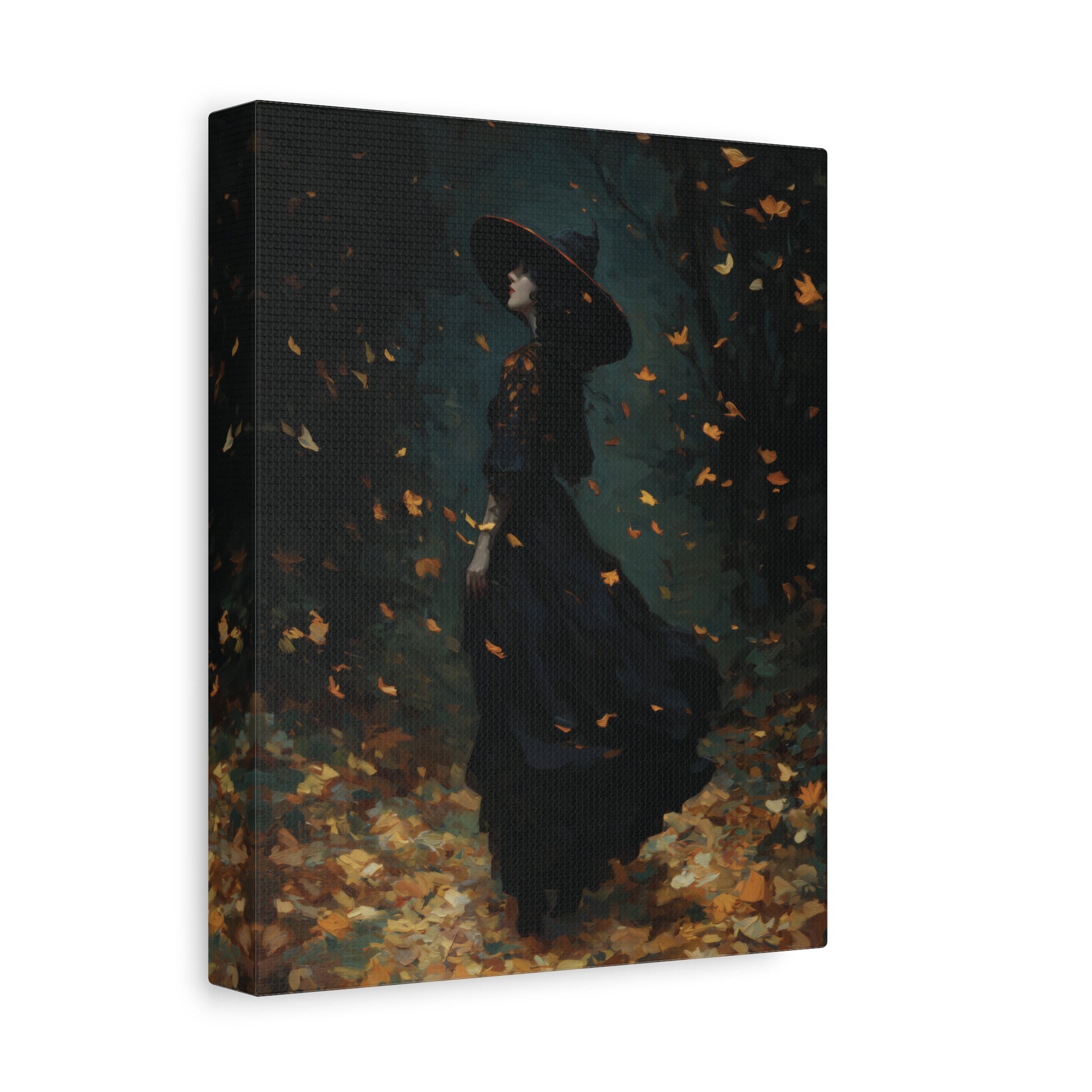 A vertical canvas wall art print showing a woman in a long black dress and wide-brimmed hat standing in a dark forest with falling orange and yellow leaves. The canvas is photographed at a slight angle against a plain white background.