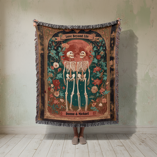 Decorative throw blanket with skeletons and floral design on a plain wall.