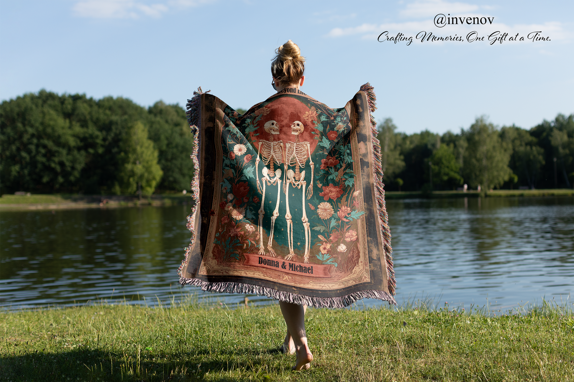 Person holding a decorative blanket with a skeleton design by a lake