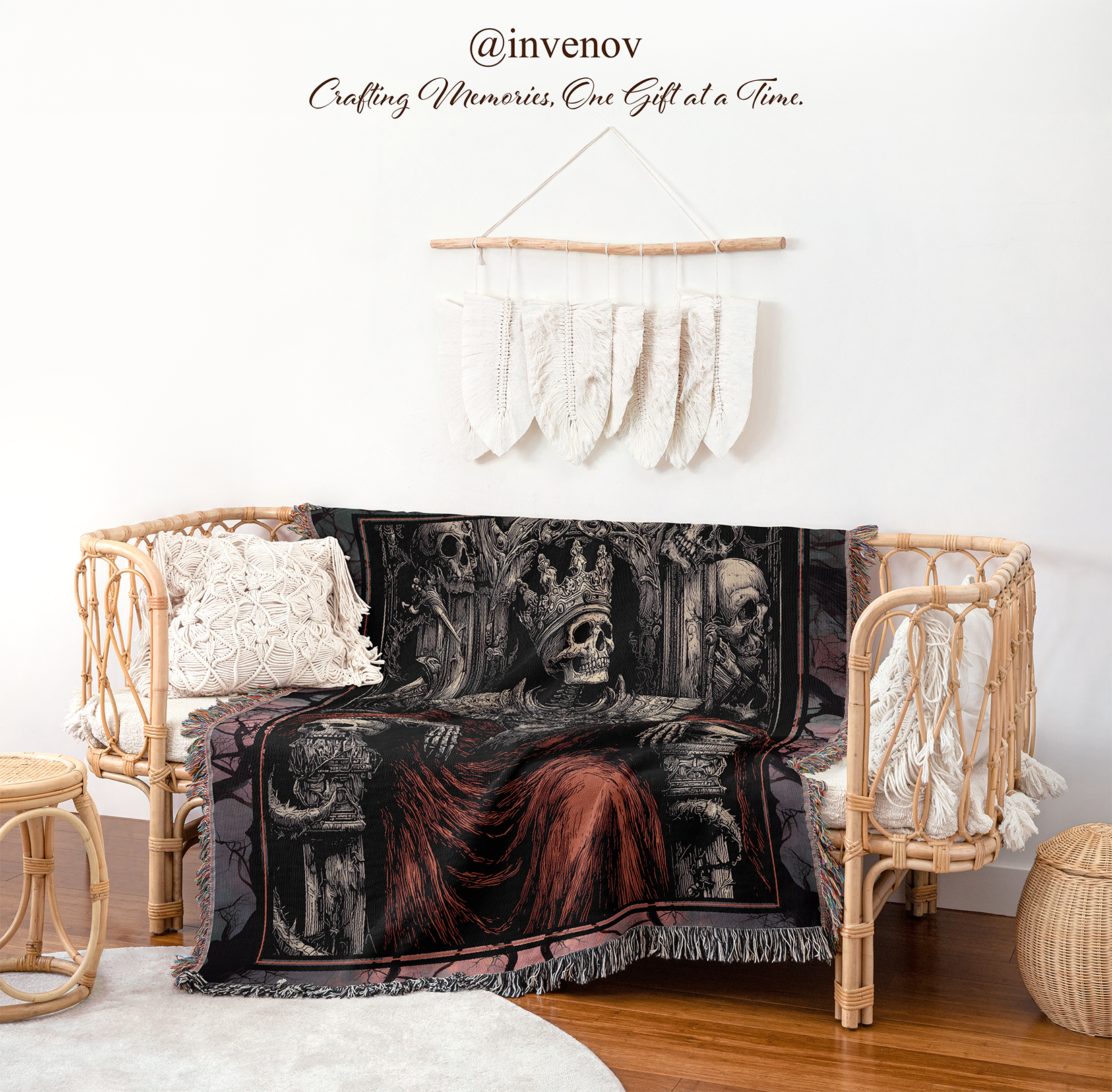 A black and red gothic-themed throw blanket draped over a rattan daybed in a styled room setting with a white wall, hanging macrame decor, and wooden floor.