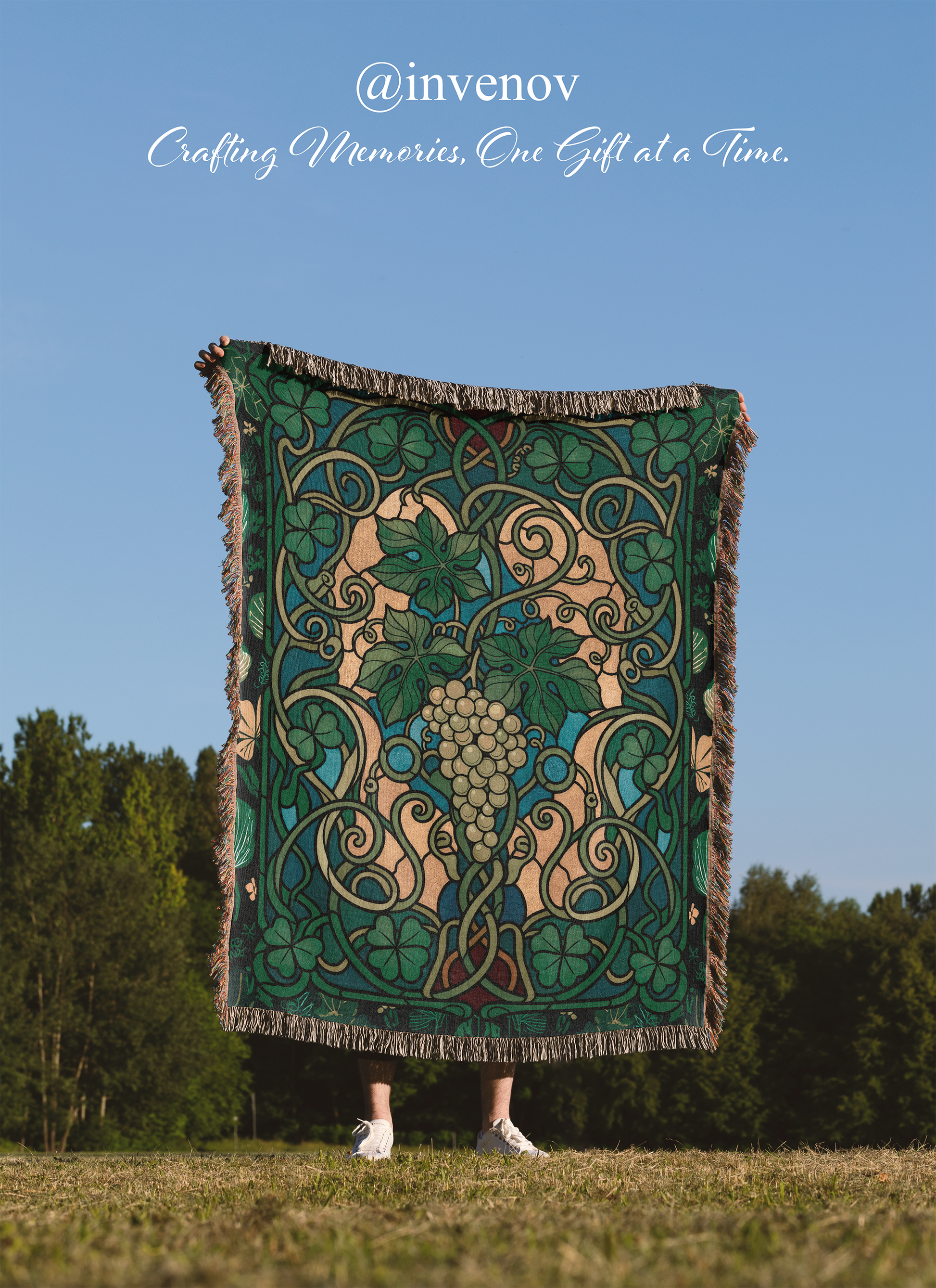Person holding a decorative blanket with intricate patterns against a blue sky and trees.