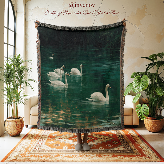 A large woven throw blanket with fringe edges is held up in a living room setting. The blanket features a printed design of several white swans swimming in a dark green water scene.