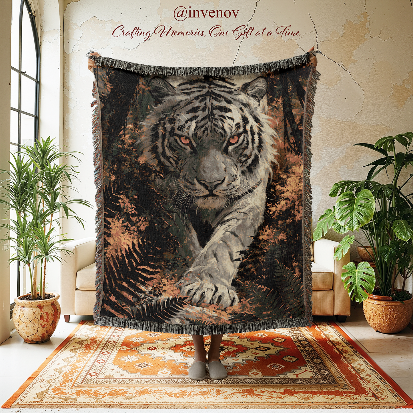 A large woven throw blanket featuring a detailed white tiger print with orange eyes and dark forest details, held up by a person in a living room setting with plants and a patterned rug.