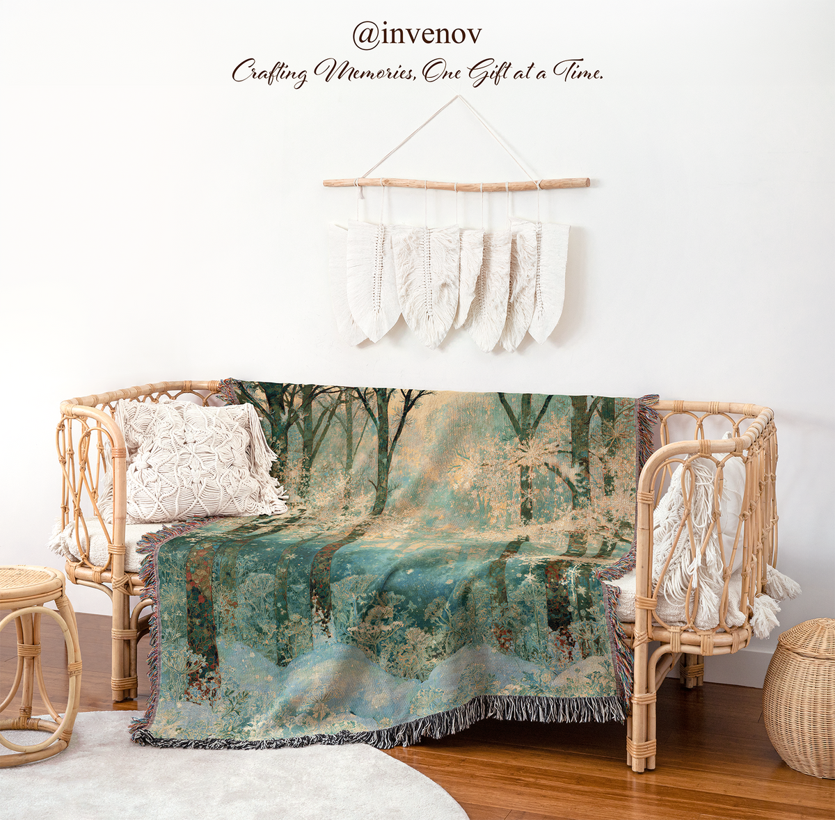 A woven rattan daybed styled in a bohemian room setting, draped with a large forest-themed throw blanket. The blanket features a detailed print of a misty woodland scene in teal, green, and brown tones.