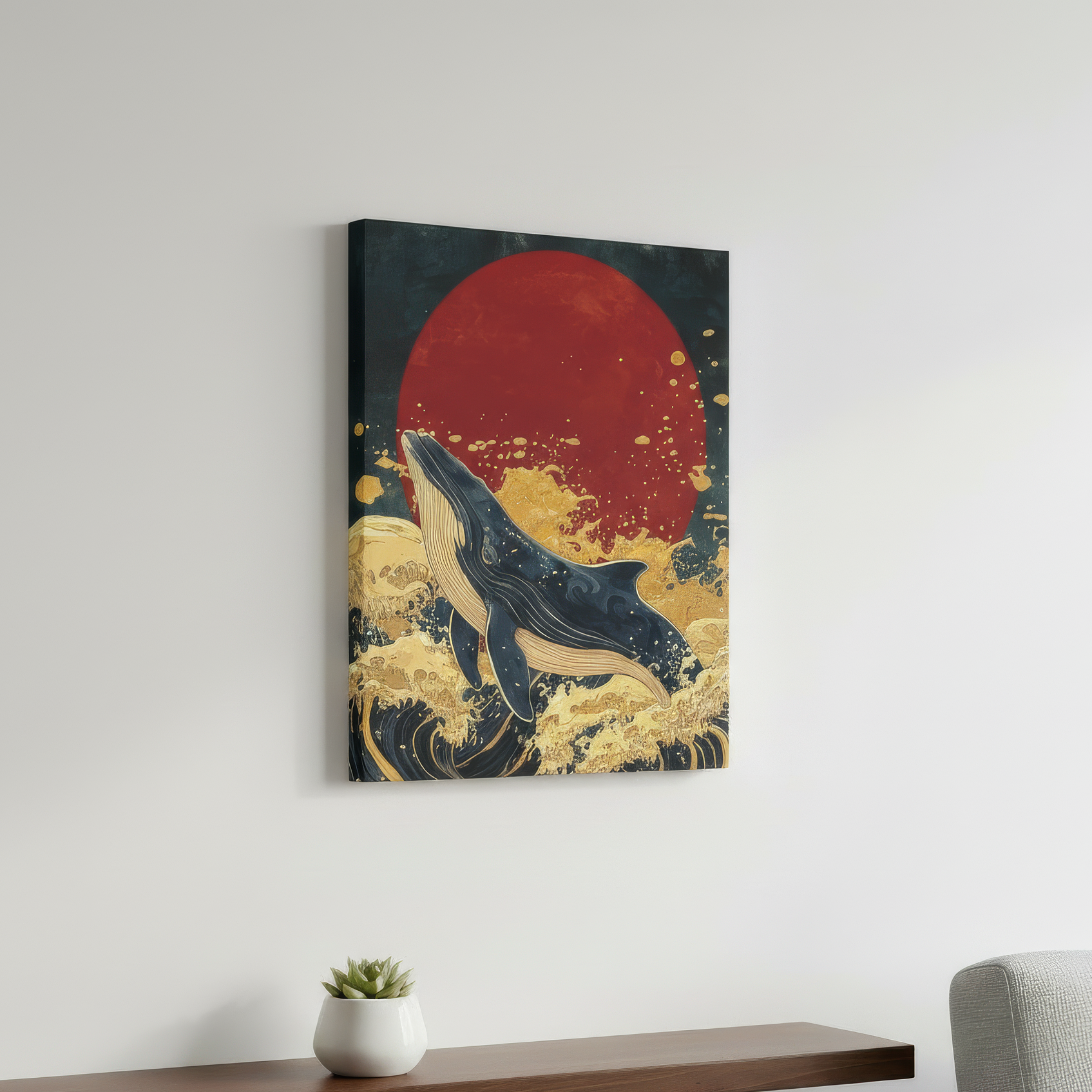Canvas print of a whale and red sun on a wall above a wooden shelf with a plant and gray chair.